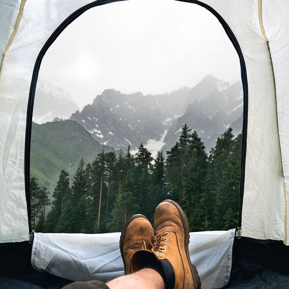Person laying in tent looking at the mountains