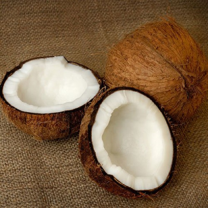 a coconut split in half on a piece of burlap