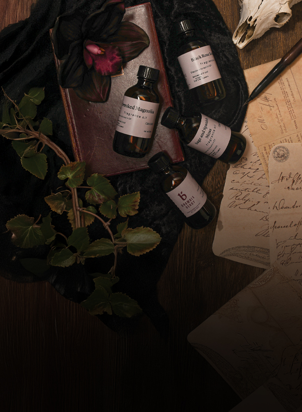 fragrance bottles with candles, books, and a skull