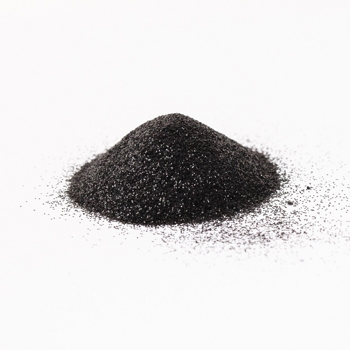 a small pile of black glitter against a white background