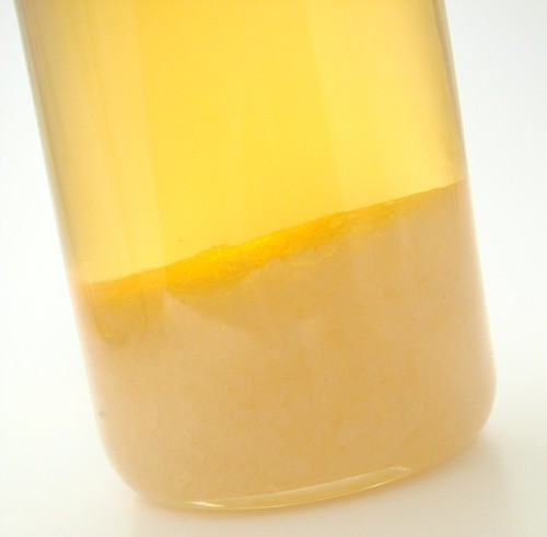 A bottle of fragrance oil with solid percipitate at the bottom