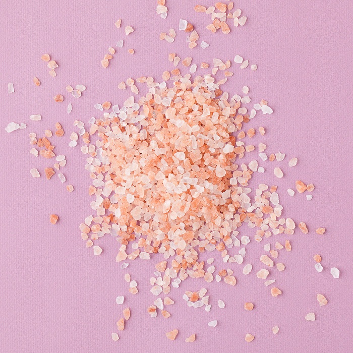 Medium grain pink sea salt against a pink
                background