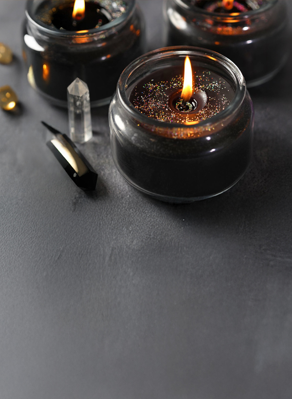 lit black candles with crystals next to them