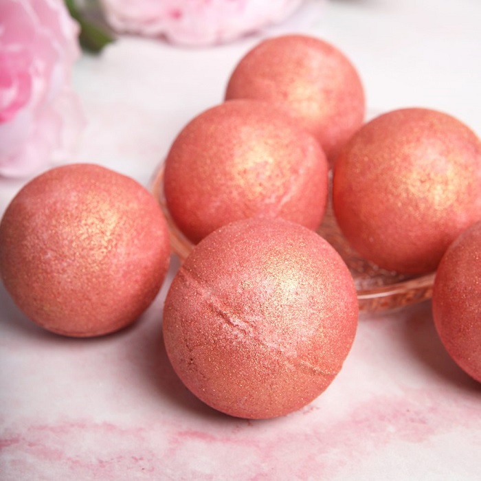 Rose gold bath bombs on a white background