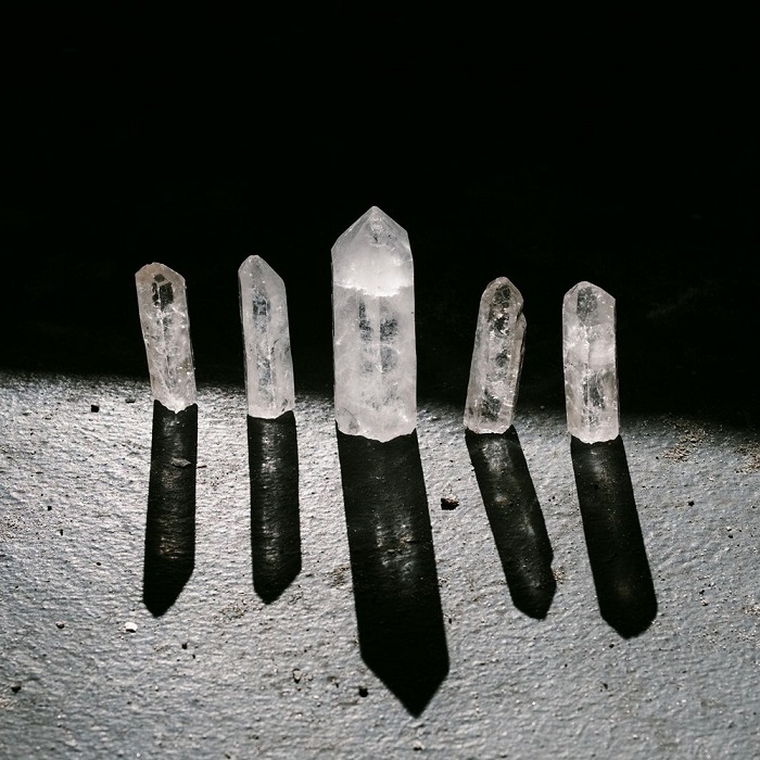 A series of quartz crystals lit by white
                light against a black background